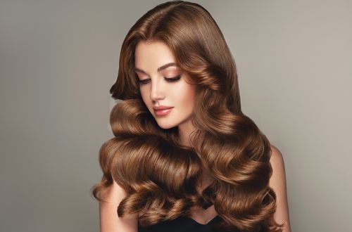 אישה עם שיער בריא לאחר שימוש במוצרי טיפוח יוקרתיים של קרסטס