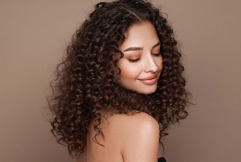 אישה מרוצה משיערה לאחר שהשתמשה בגלייז לשיער